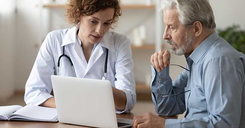 DOCTOR-PATIENT-LOOKING-LAPTOP