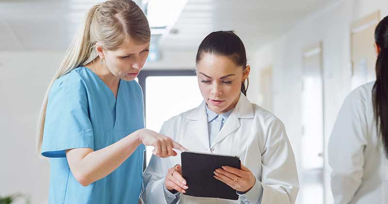 Two medical staff watching tablet