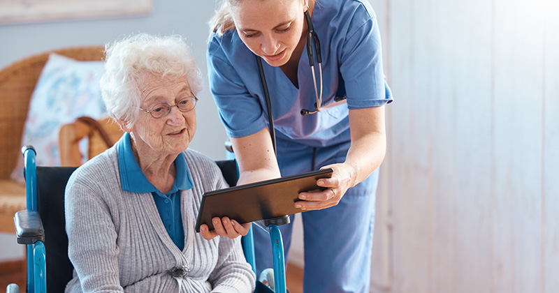 NURSE SHOWING ELDERLY PATIENT IPAD