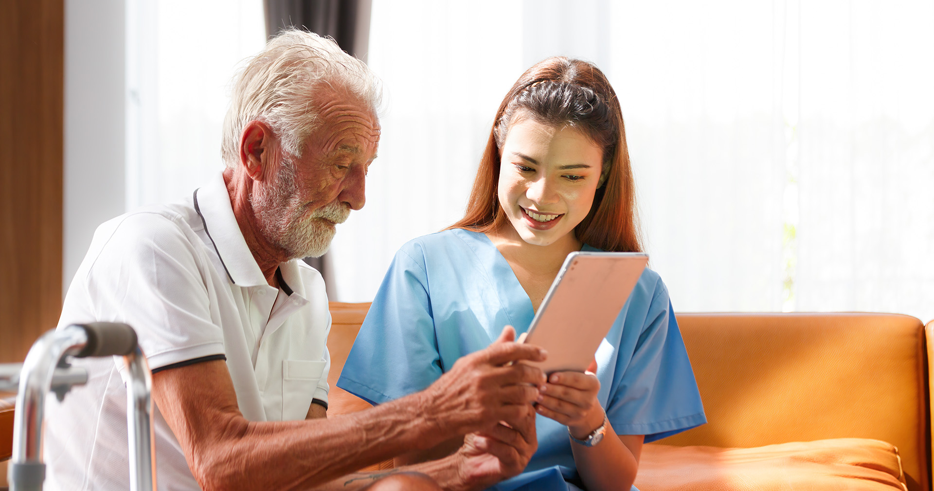 NURSE WITH ELDERLY MAN AND IPAD