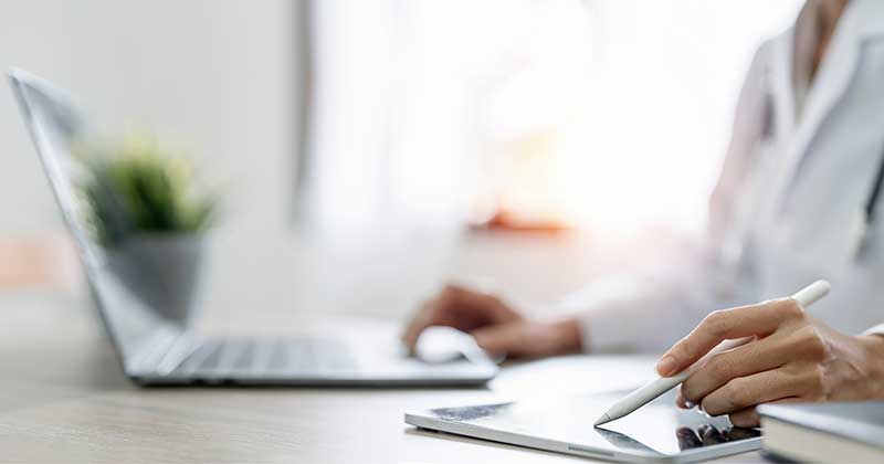 Doctor writing tablet with pen